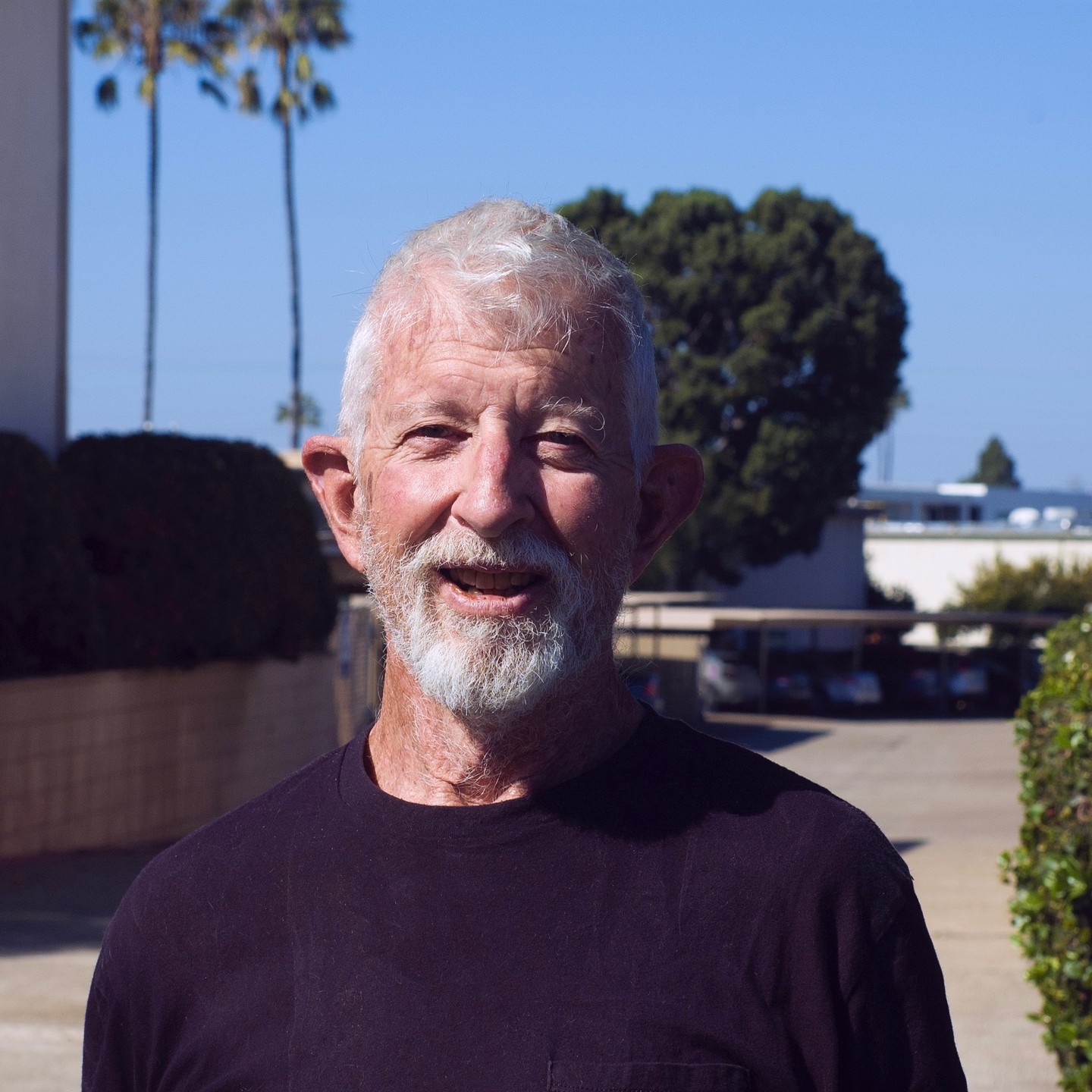 Photo of a smiling older gentleman wearing a black t shirt.