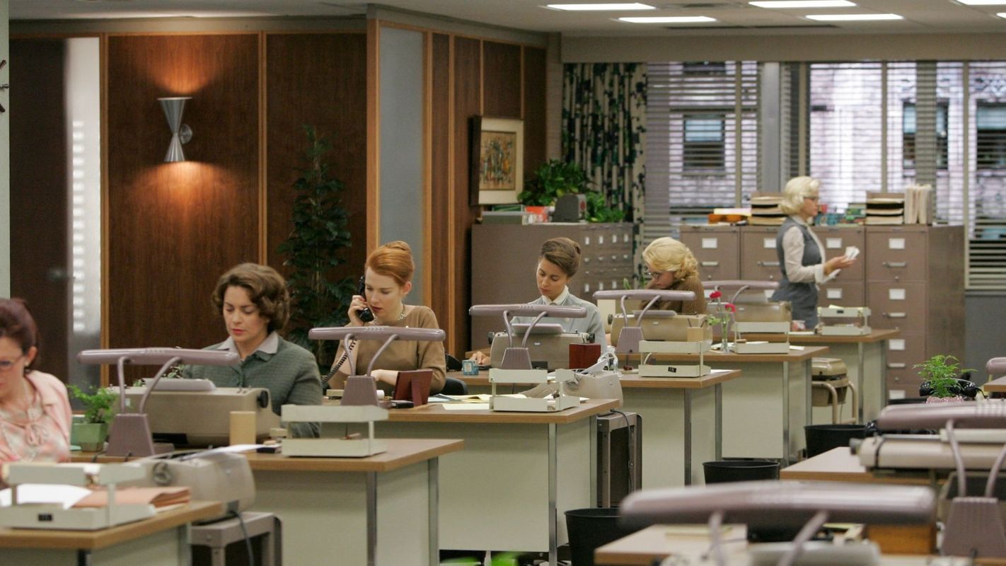 Still shot from the TV show Mad Men, depicting a row of secretaries working at their desks.